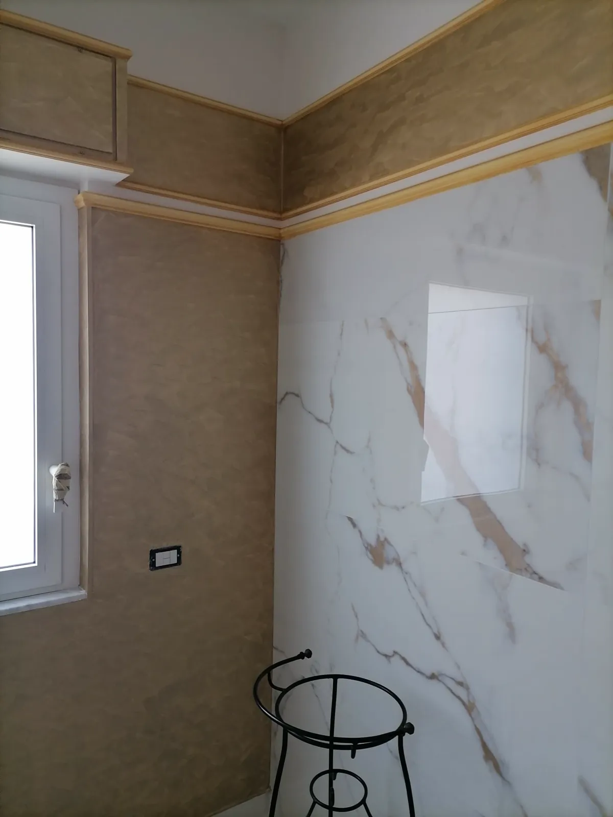 Stanza con parete a effetto marmo e stucco ocra